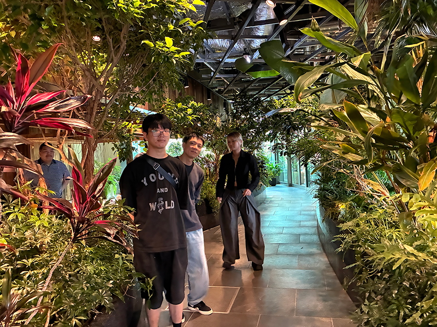 高輪ゲートウェイ駅周辺の屋内植栽エリアを歩く敬愛大学国際学部2年庄司ゼミの学生。SDGs目標13「気候変動に具体的な対策を」の調査では、植栽が暑さを和らげ、環境への配慮が人の快適さにつながることを確認した。